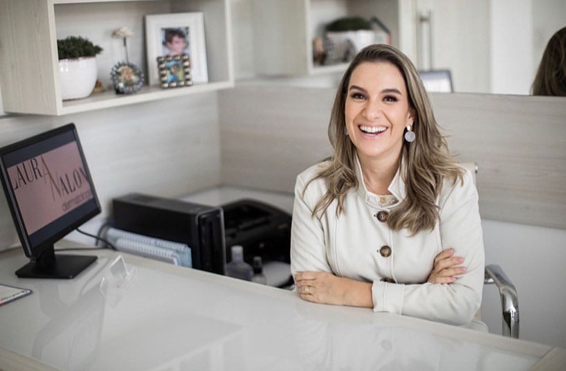 Dra. Laura Nalon sorrindo em seu consultório