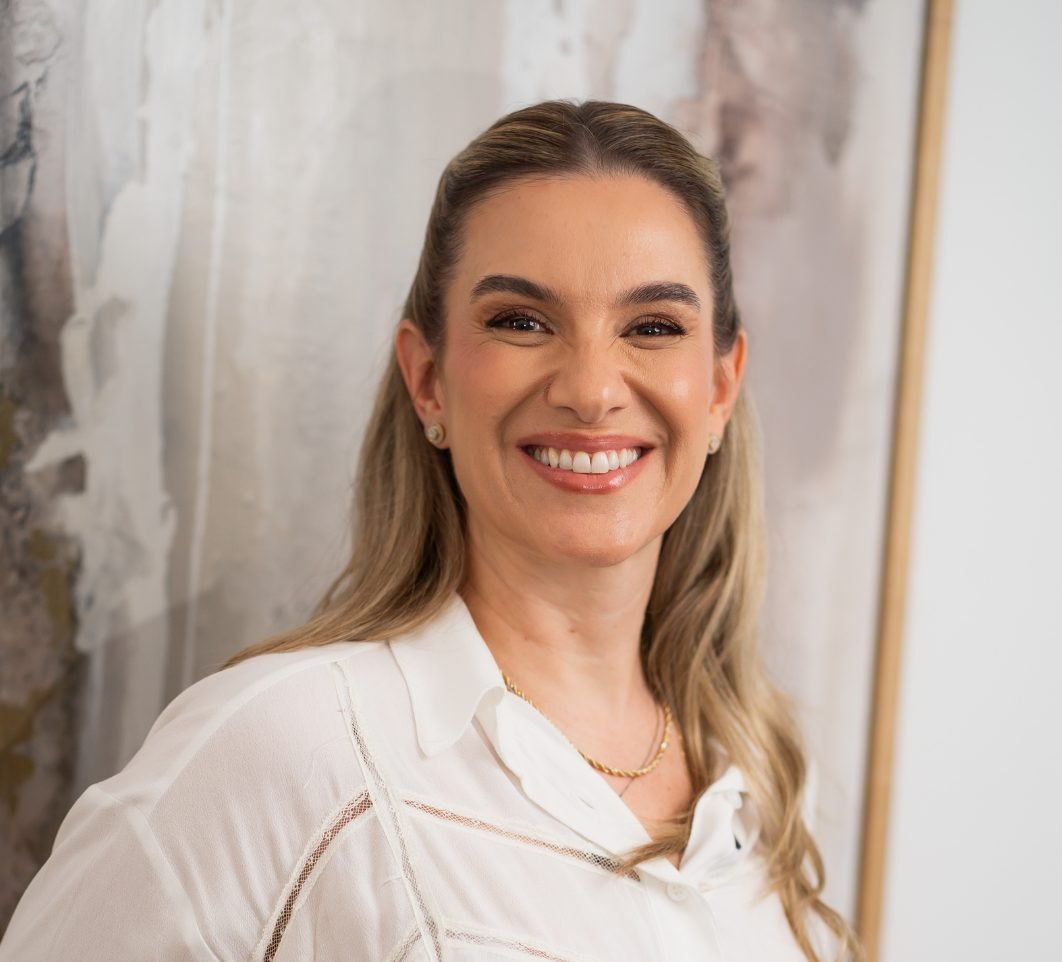Retrato da Dra. Laura Nalon sorrindo, de blusa branca